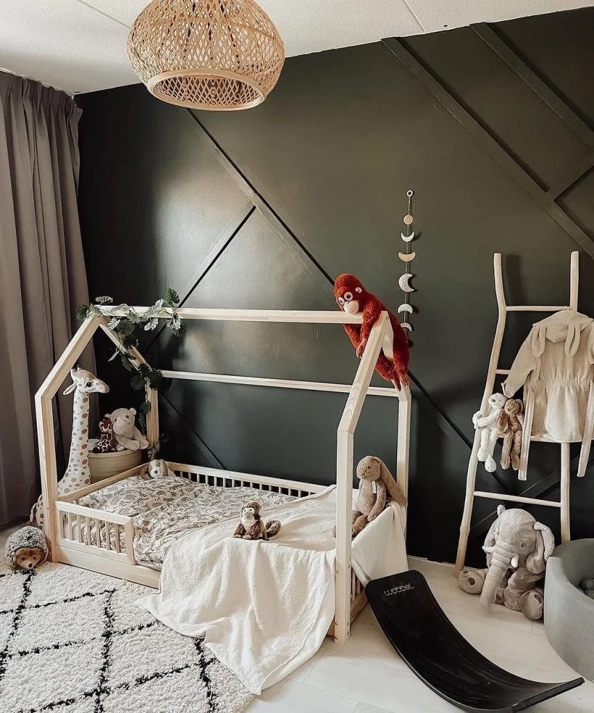 Nature-inspired kids room with green walls and botanical prints.